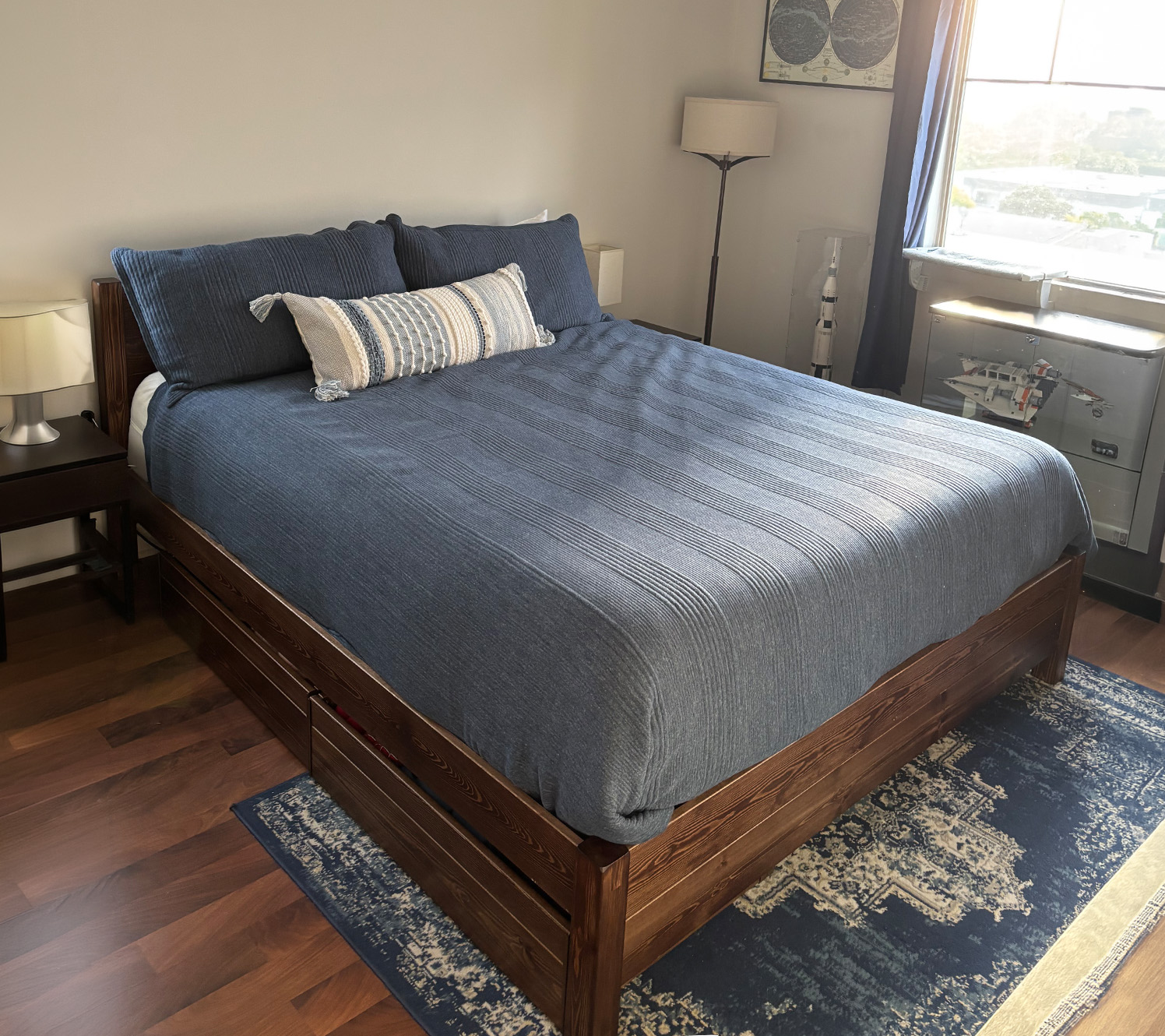 Blau-graues Schlafzimmer mit Holz-Bettgestell